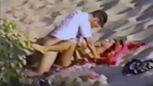 Young couple bends over at the beach